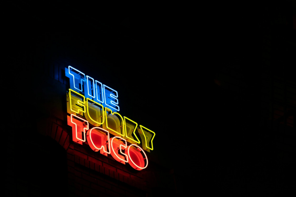 A neon sign that reads 'The Funky Taco.' Good brand names can come in many ways.