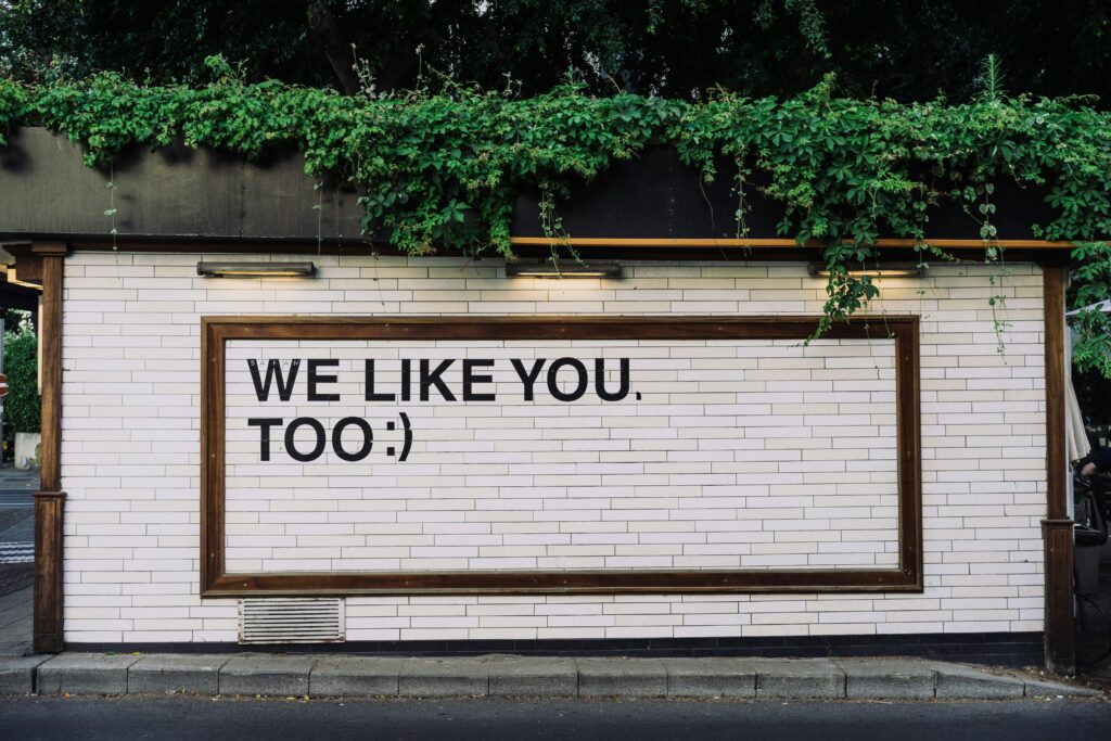 A sign saying 'We like you, too :)". Being authentic helps you avoid a social media crisis.