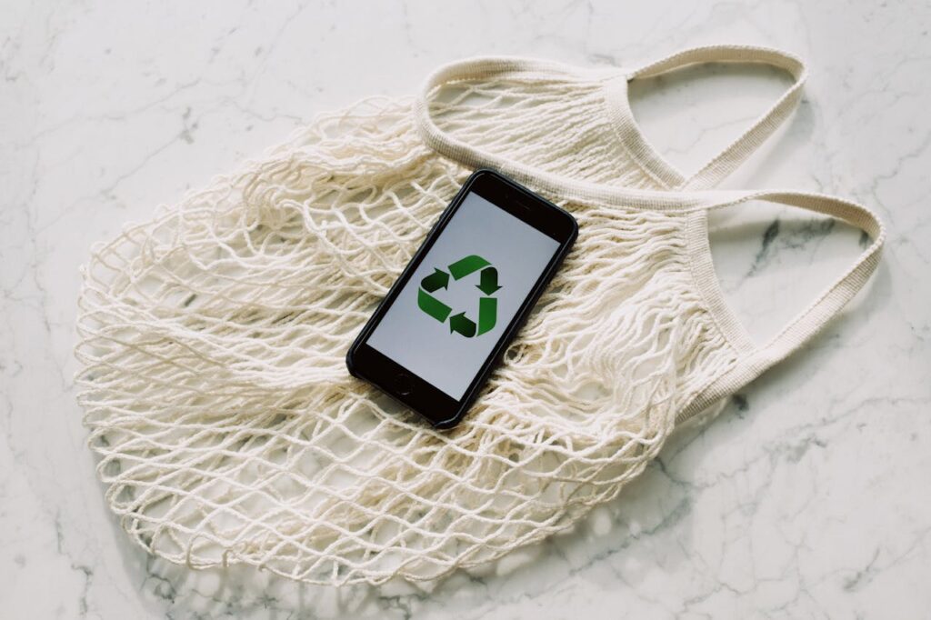 mobile phone resting on a compostable reusable shopping bag, symbolising sustainability 